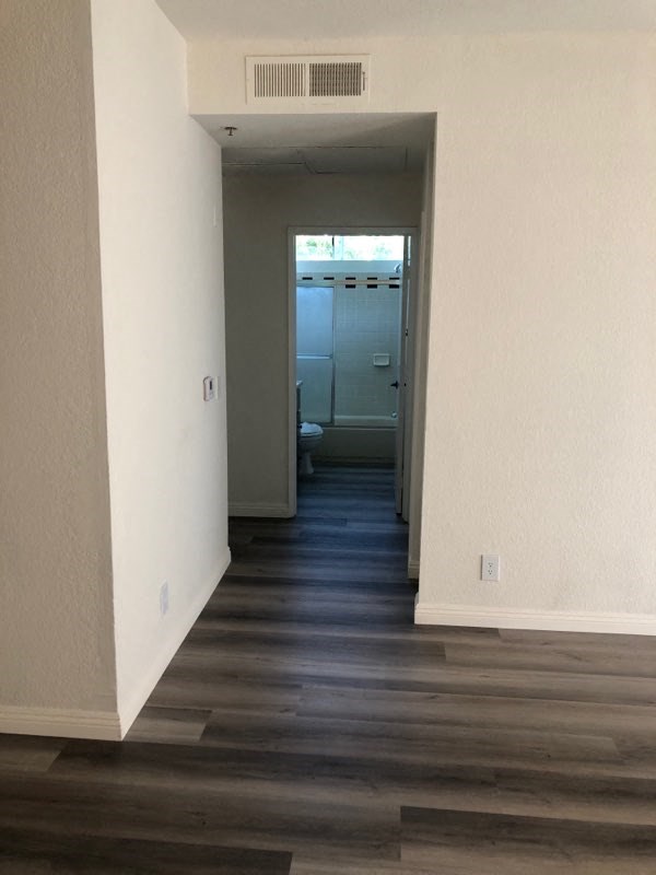 a hallway with a wood floor and white walls