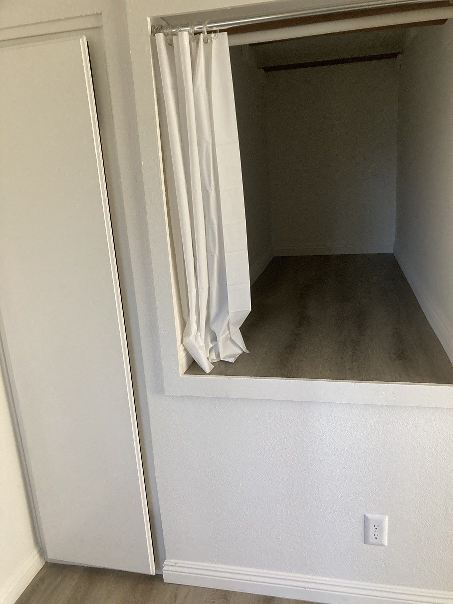 a closet with a window and a curtain