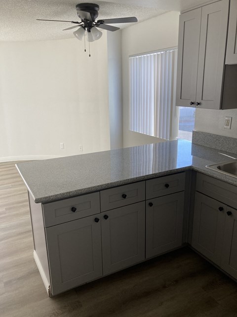 an empty kitchen with a counter top and a window