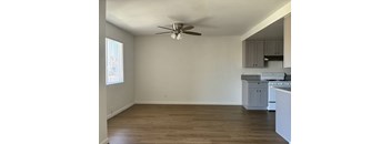 A room with a ceiling fan and wooden flooring.
