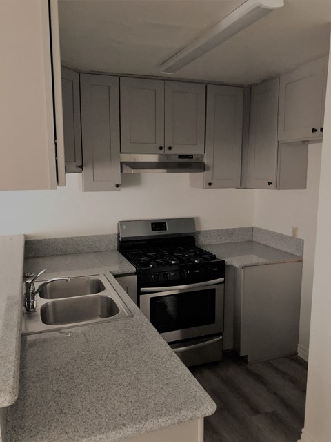 an empty kitchen with a sink and a stove
