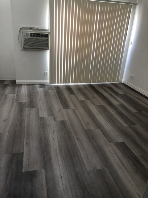 the living room has hardwood flooring and a wall heater