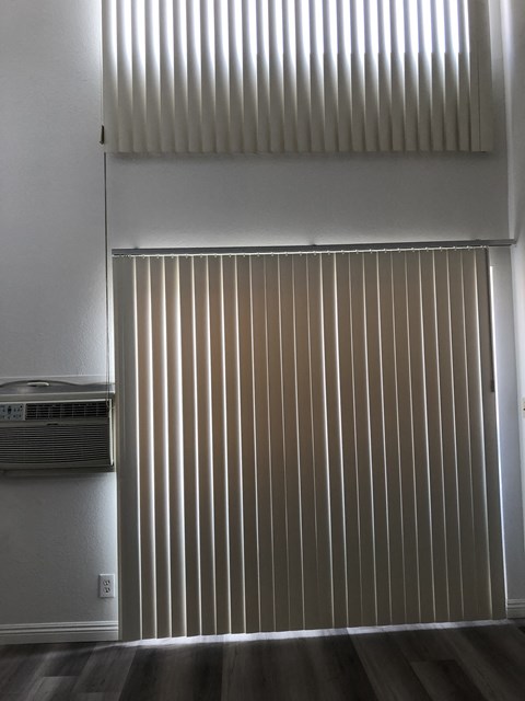 a large window with white blinds and a radiator on the wall