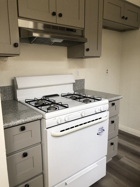 an empty kitchen with a stove and a microwave
