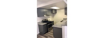 A kitchen with a stove, oven, and cabinets.