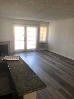 an empty living room with wood floors and a fireplace