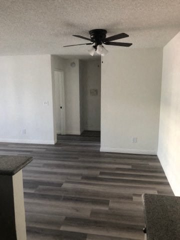 a living room with a ceiling fan and white walls