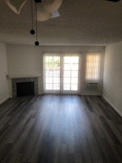 an empty living room with wood floors and a fireplace