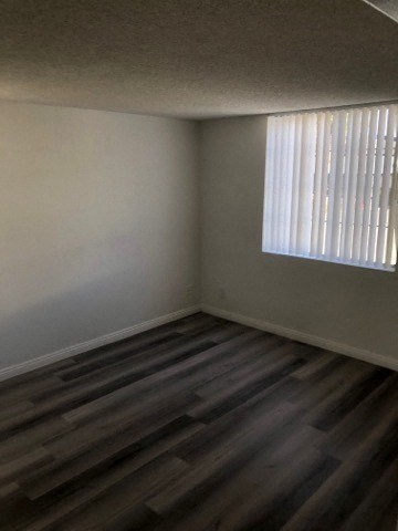 an empty room with wooden floors and a window