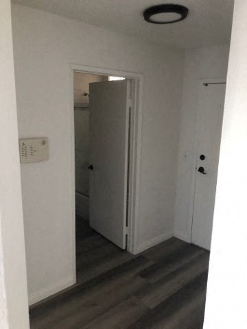 a white room with a door and a hallway