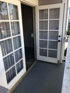 a door is open to a hallway with a black floor