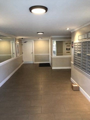 a hallway with white walls and a tile floor