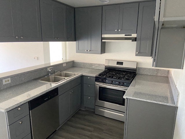 a kitchen with stainless steel appliances and gray cabinets