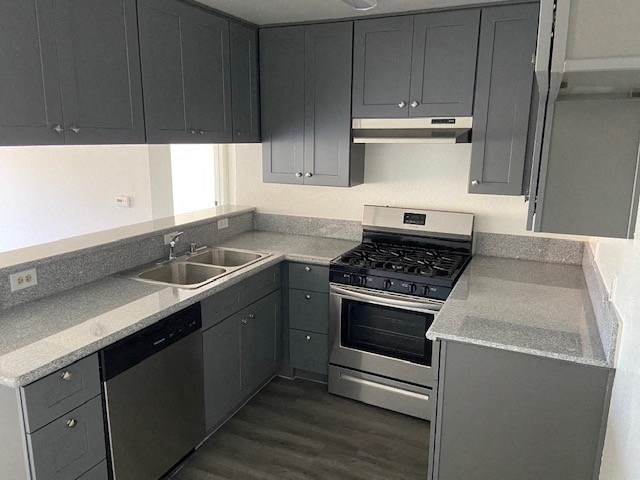 a kitchen with stainless steel appliances and gray cabinets