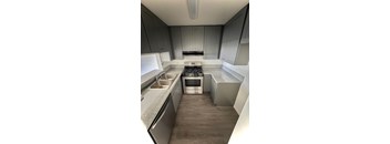 A kitchen with a stove top oven and a sink.