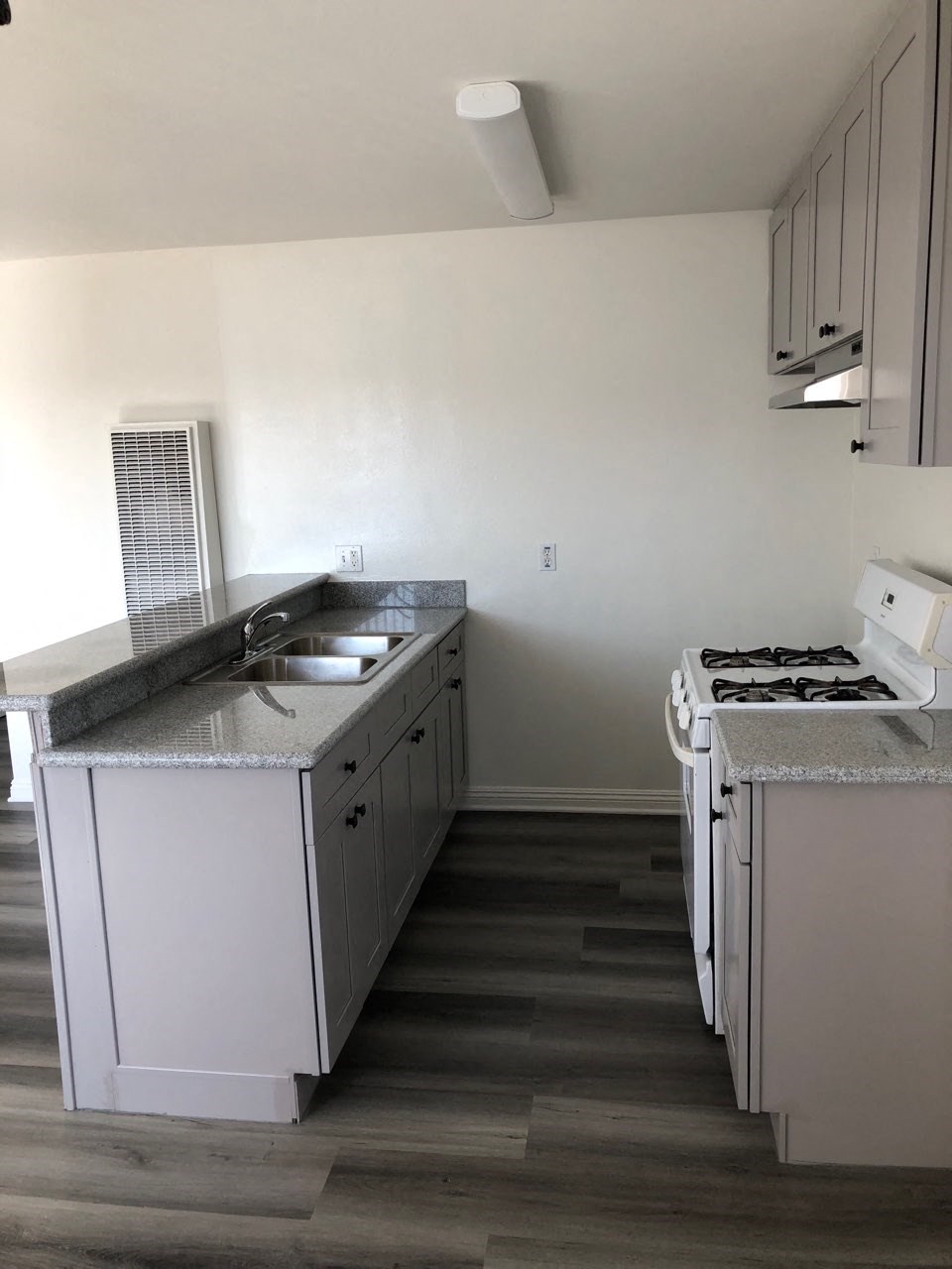 a kitchen with white cabinets and a sink and a stove