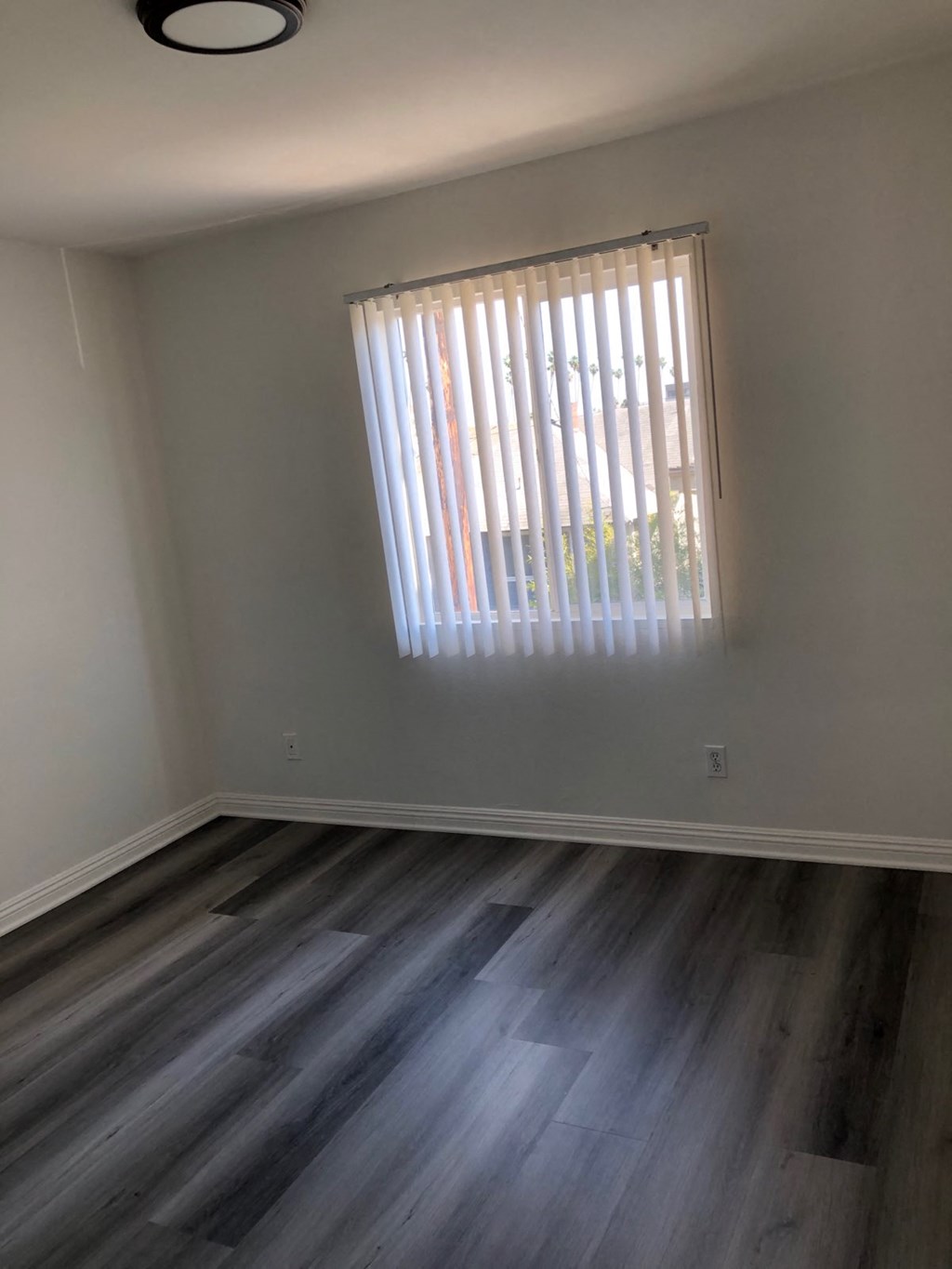 a empty room with wooden floors and a window