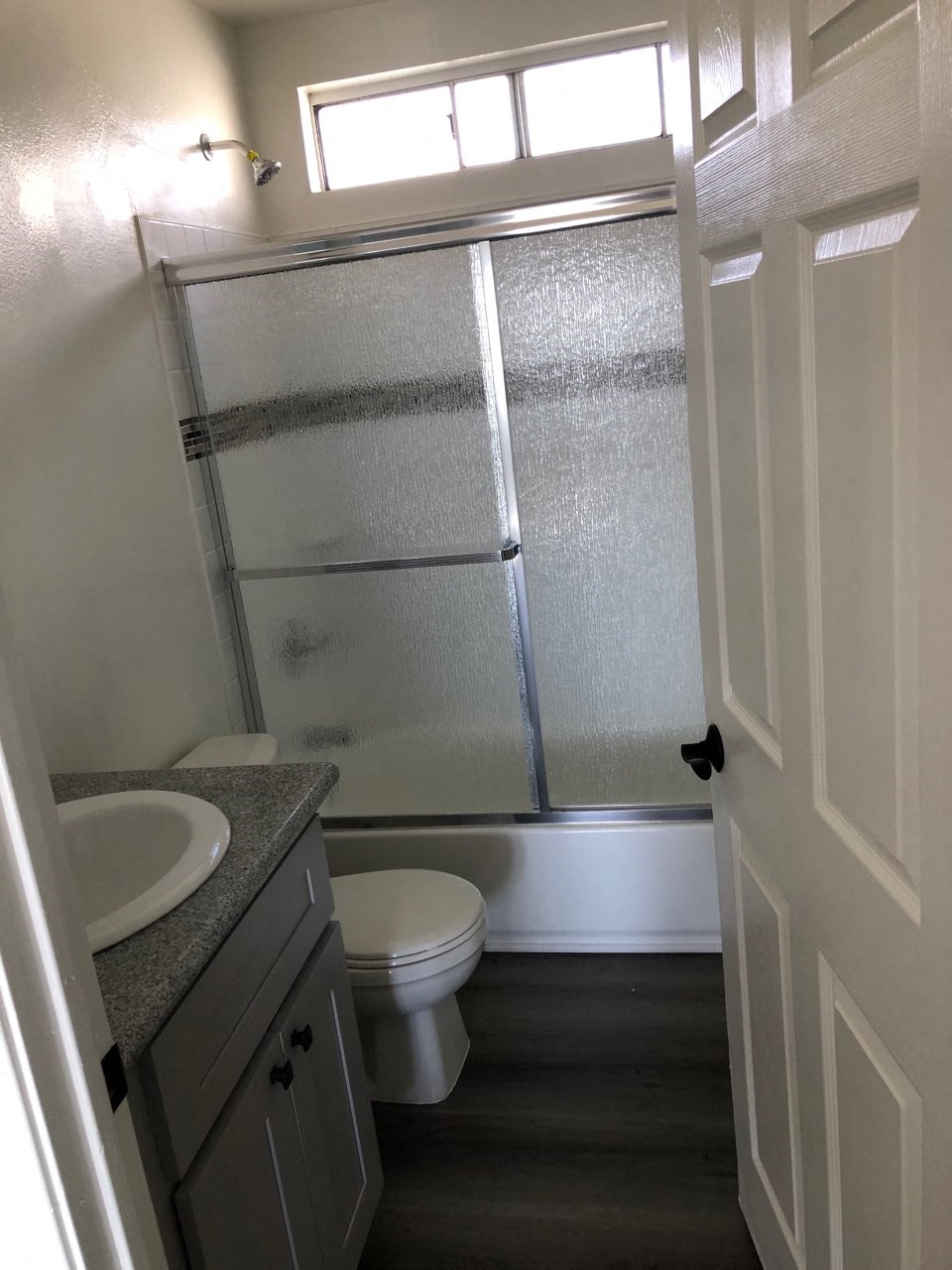 a small bathroom with a shower toilet and sink