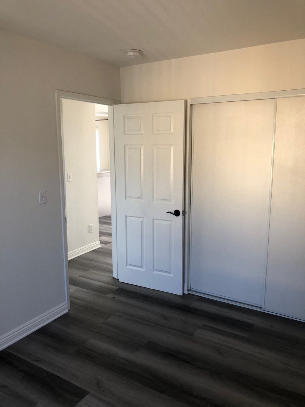 a living room with white doors and a wood floor