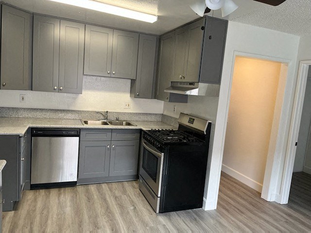 an empty kitchen with a stove and a sink
