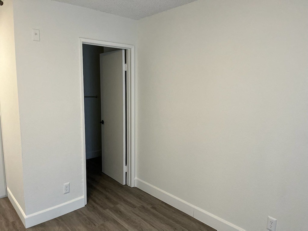 a bedroom with white walls and a door to a closet
