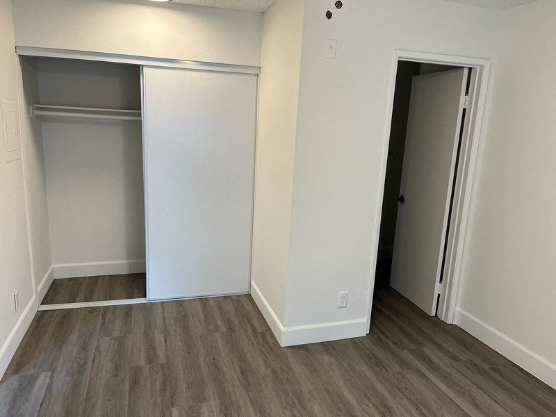 an empty room with a closet and a door open