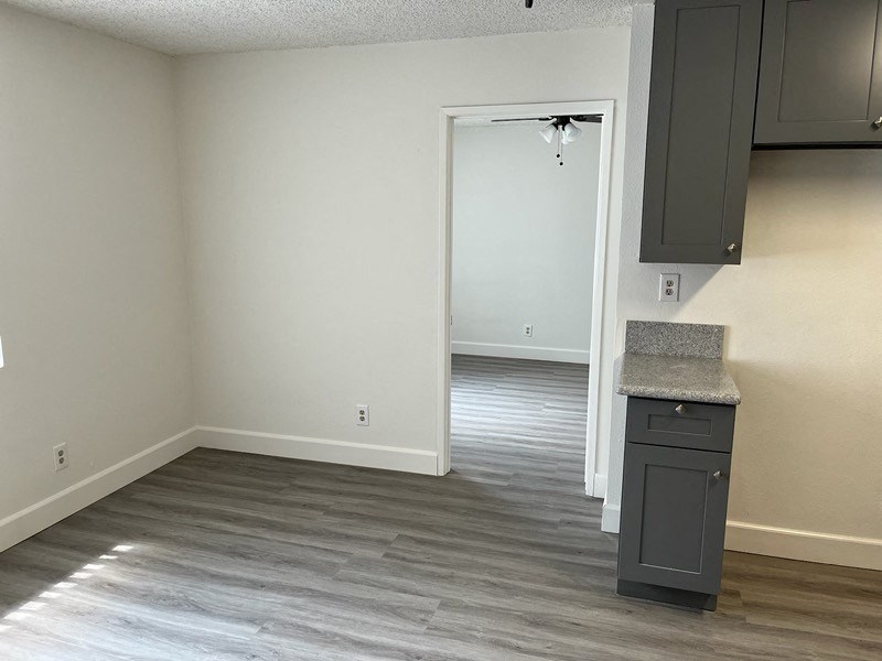 an empty kitchen and living room with a door to a closet