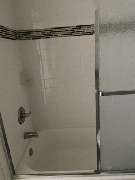 a bathroom with a shower with a glass door
