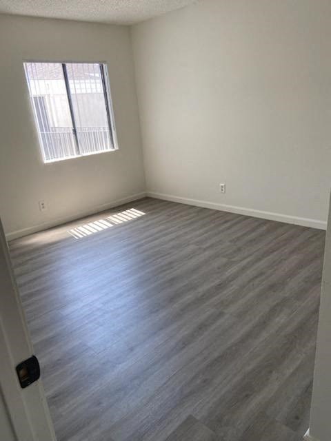 an empty room with wooden floors and a window