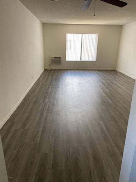 an empty living room with wooden floors and a window