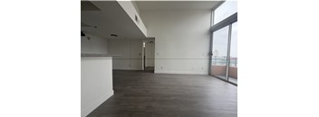 A large empty room with wooden floors and white walls.