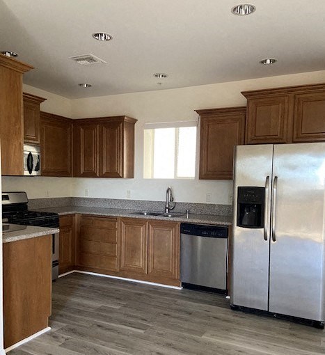 a kitchen with wooden cabinets and a stainless steel refrigerator