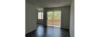 A room with a sliding glass door leading to a balcony.