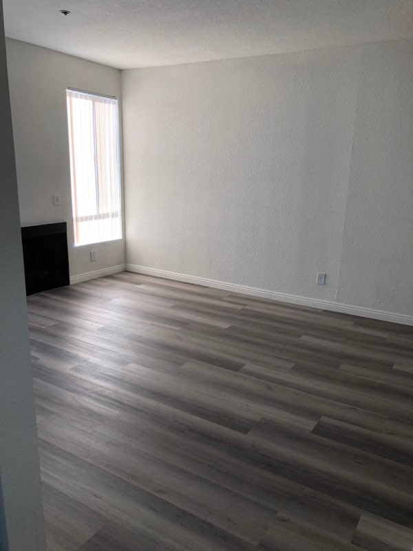 a living room with wooden floors and a window