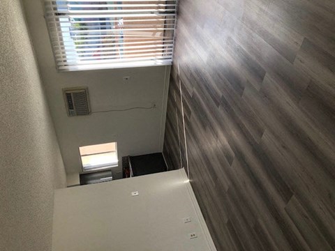 a small room with a refrigerator and a window