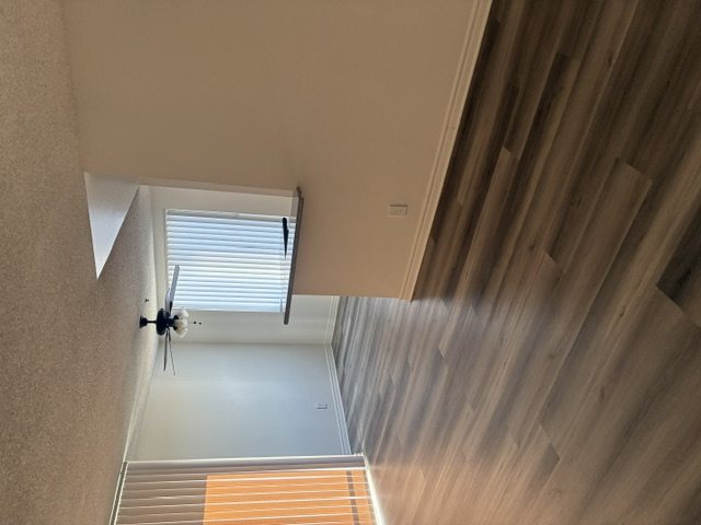 A staircase with wooden slats leading to a window with blinds.