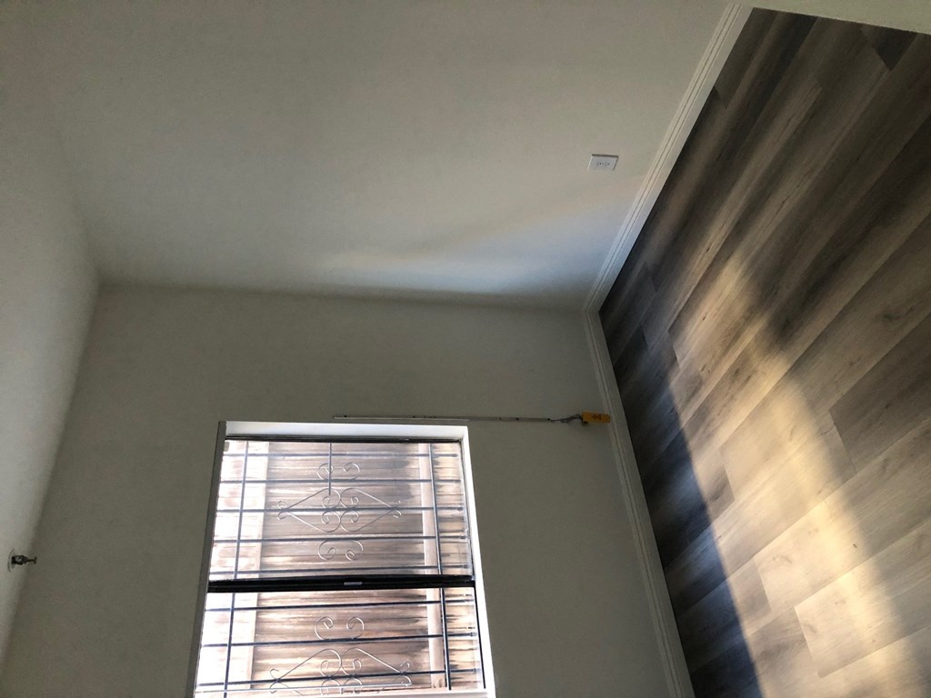 the ceiling and window in a room with a wood wall