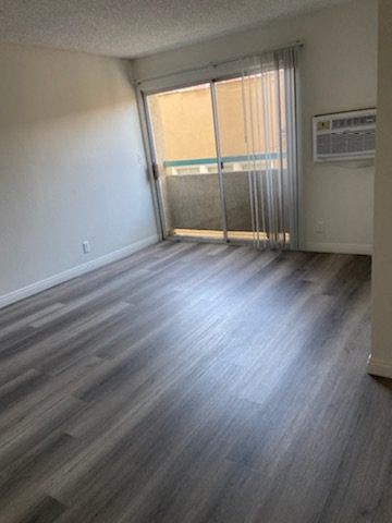 an empty living room with wood floors and a window