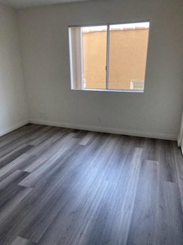 an empty room with wooden floors and a window