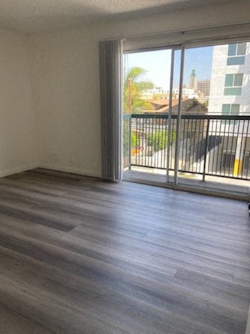 a living room with a wood floor and a balcony