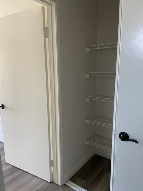 a bathroom with an empty closet and a white door