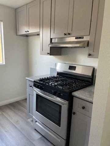 a kitchen with a stove and a microwave and white cabinets