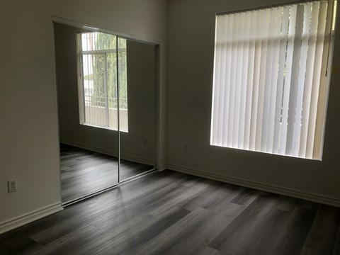 A room with a sliding glass door and a window with blinds.