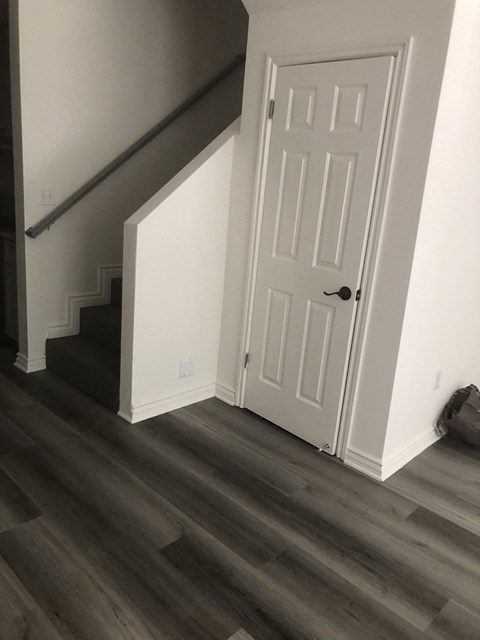 A white door is on the right side of a staircase.