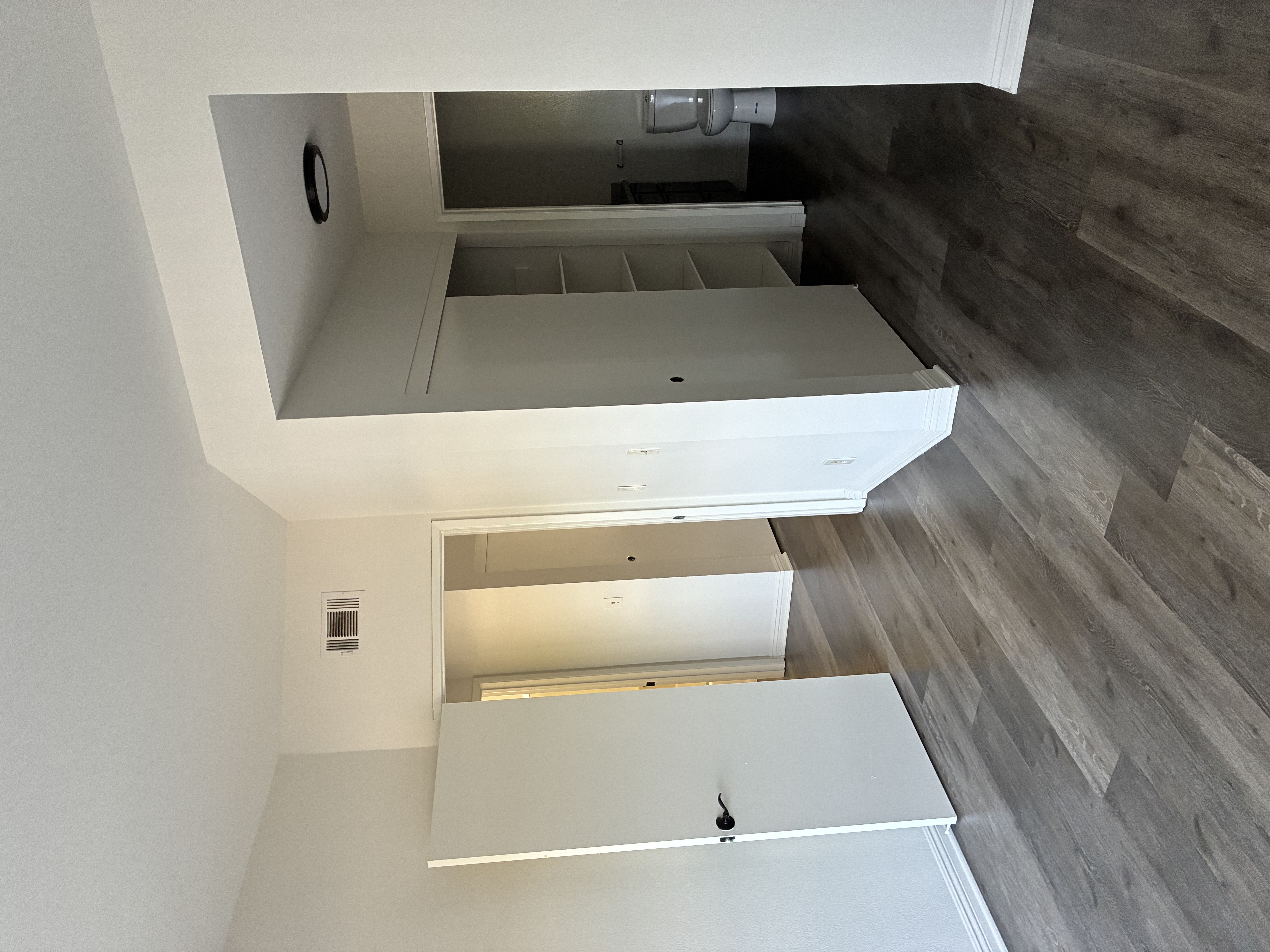 A white kitchen with a wooden floor.