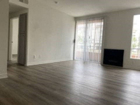 an empty living room with wood floors and a television