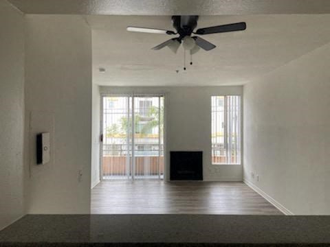 an empty living room with a ceiling fan