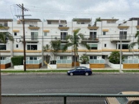 a blue car parked in front of an apartment building