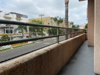 a balcony with a fence and a view of a street