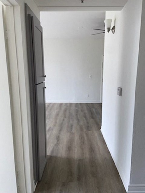 a room with white walls and wooden floors and a door